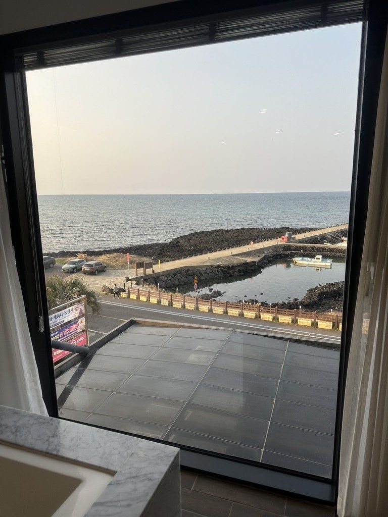 Aewol sea and coastal road seen from the window of the Suite Ocean room at Dyne Oceano Hotel, Jeju